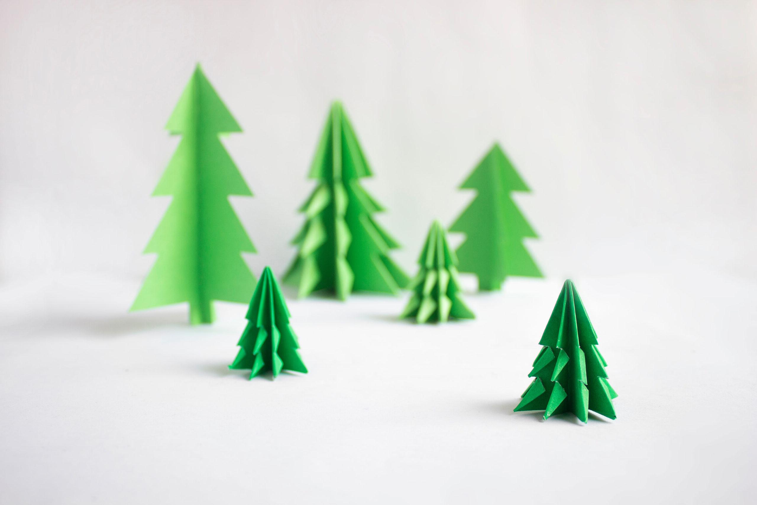 6 green paper pine trees on a light gray background